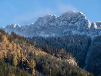 Herbstwald unterhalb komplettem Kampenwand Massiv mit erstem Schnee